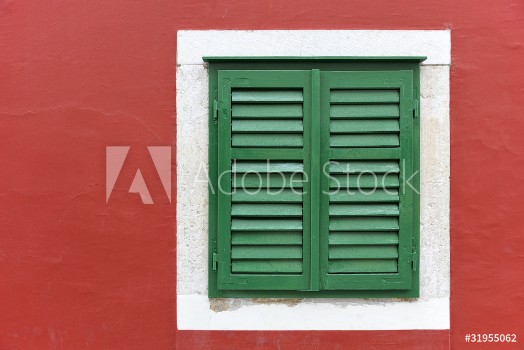 Picture of Single window with green shutters set in red wall in Skradin